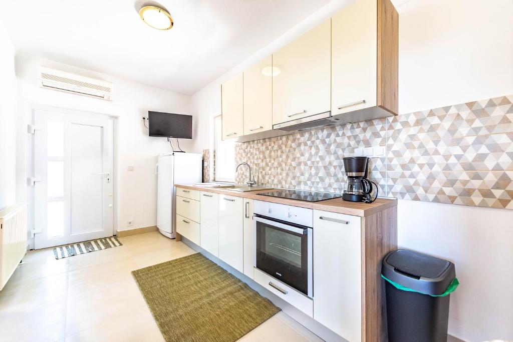 a kitchen with white cabinets and a counter top at Apartment Stanka in Novalja