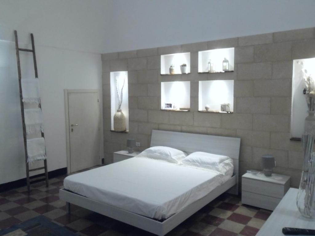 1 dormitorio con 1 cama blanca y 2 ventanas en CASA MARI, en Laterza