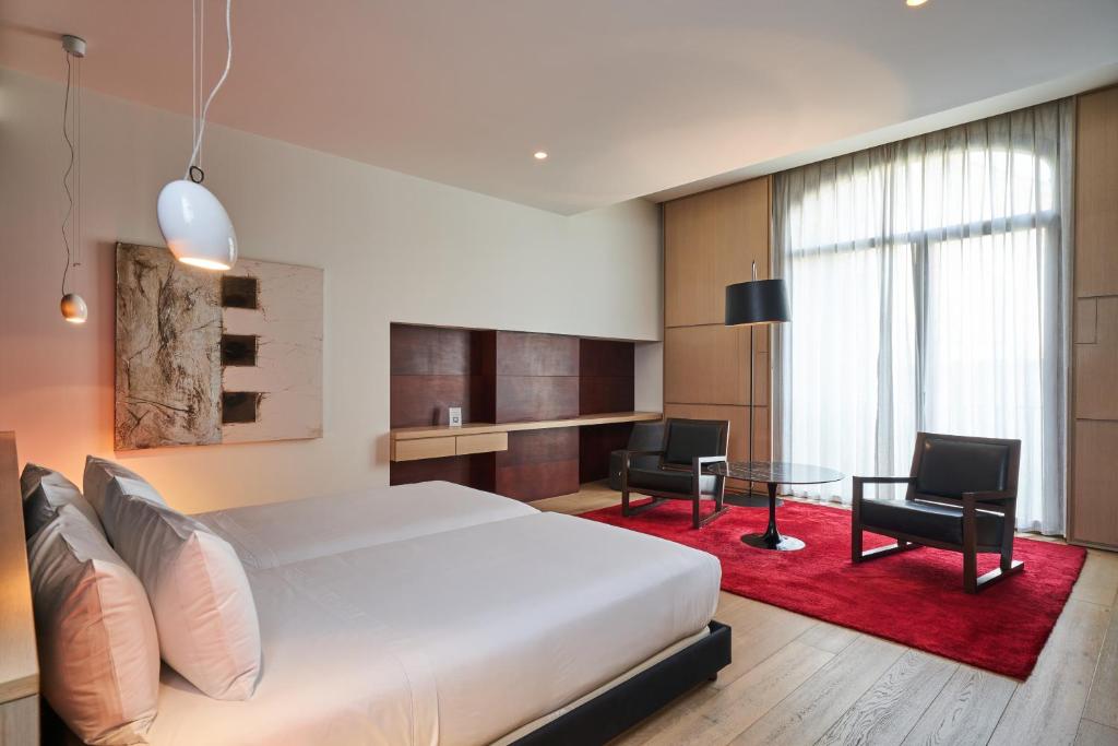 a bedroom with a bed and a table and chairs at Mercer Casa Torner i Güell in Vilafranca del Penedès