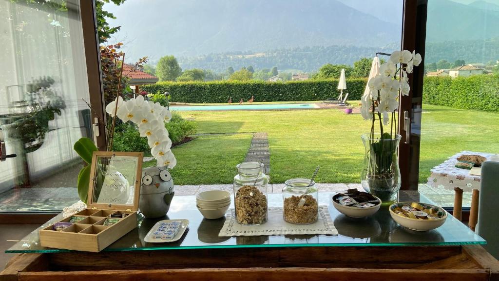 een tafel met eten erop met uitzicht op een tuin bij LA TANA DEL GRILLO in Feltre