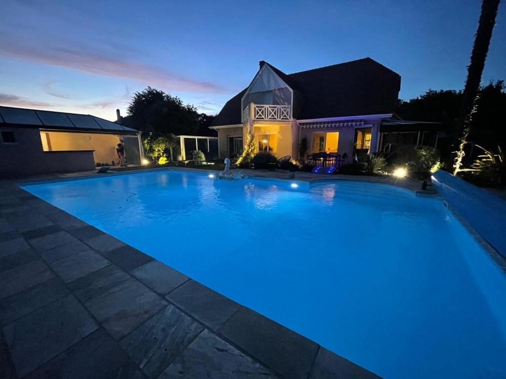 a large swimming pool in front of a house at night at Casa des Augas in Ousse