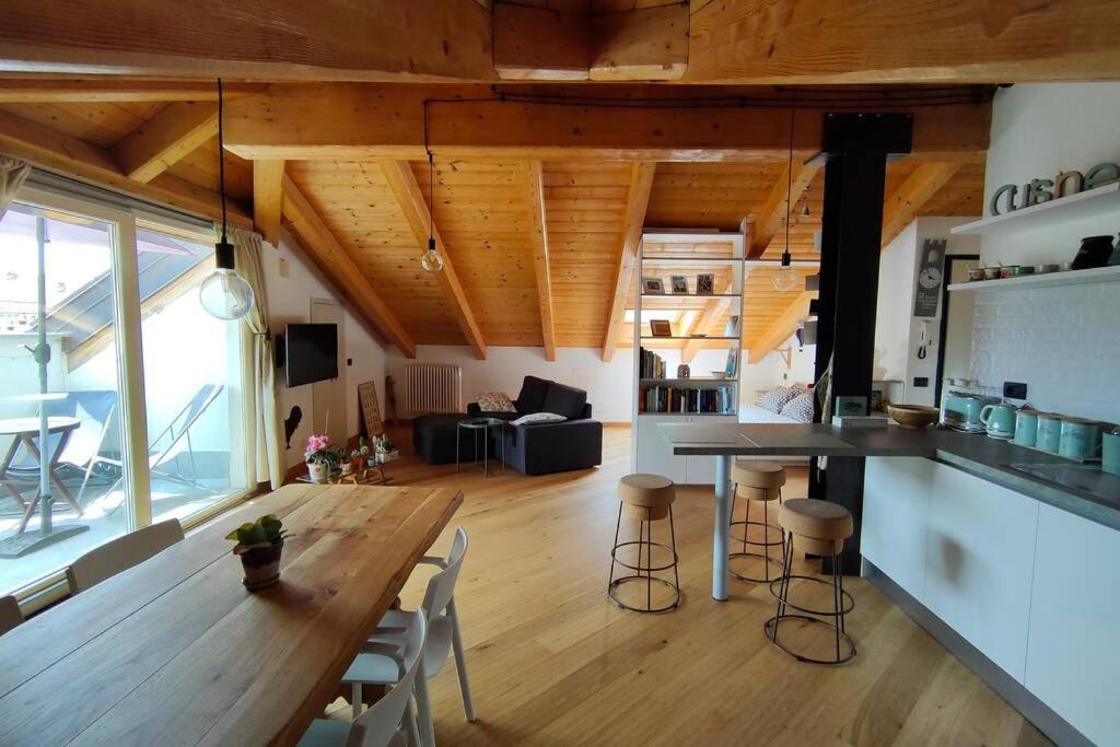 a kitchen and living room with a large wooden table at La Pentajota • camera con vista in Mondovì