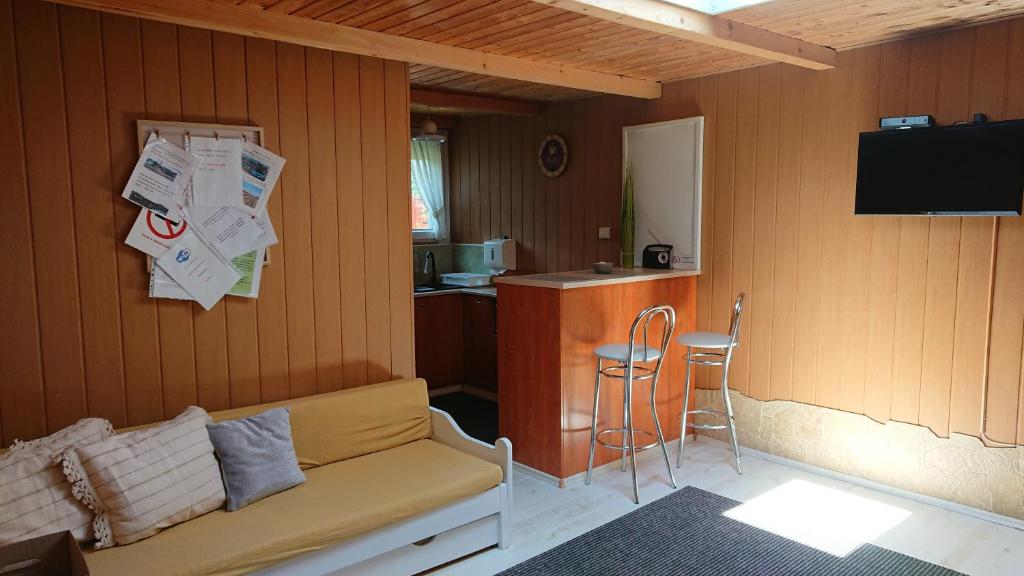 ブダペストにあるBpR P3 Lodge Apartment with A/Cのソファ付きの部屋、バー付きのキッチンが備わる客室です。