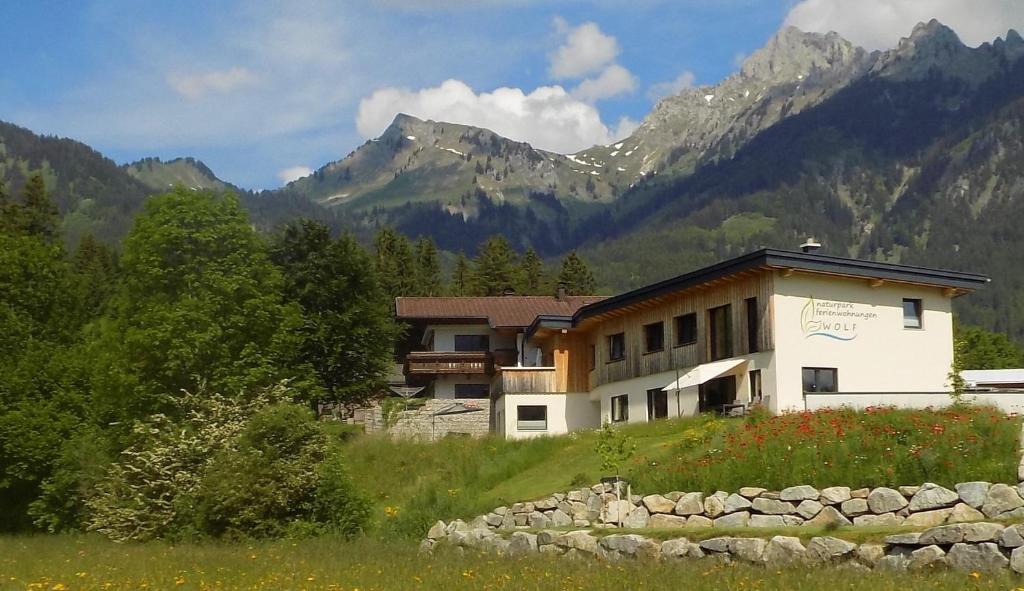 a building in a field with mountains in the background at Naturparkferienwohnungen Wolf in Hofen