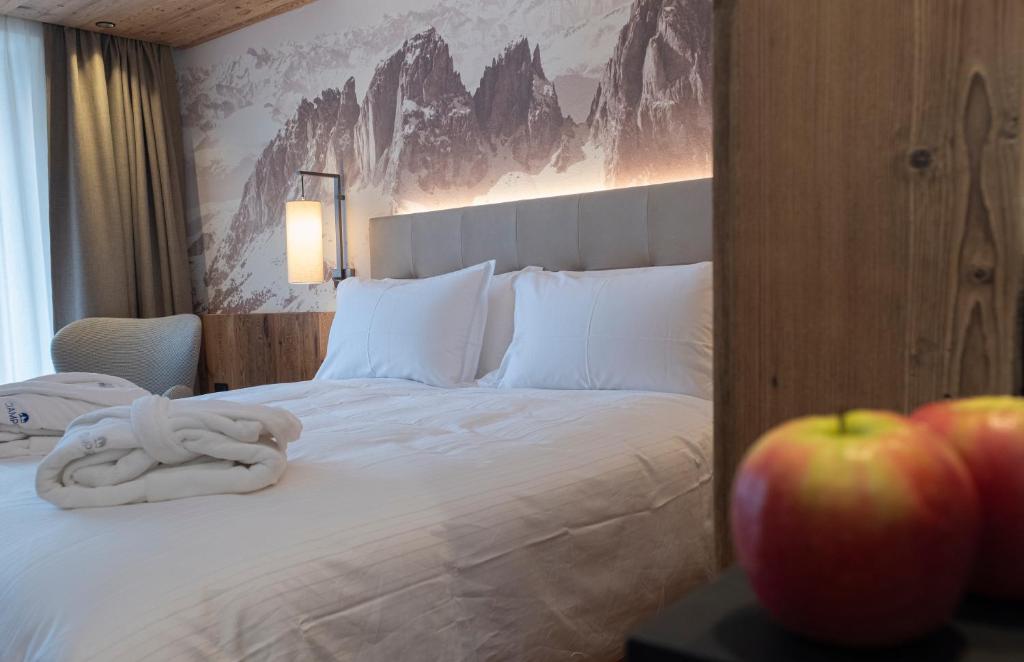 a bedroom with a bed with an apple on a table at Ciampedie Luxury Alpine Spa Hotel in Vigo di Fassa