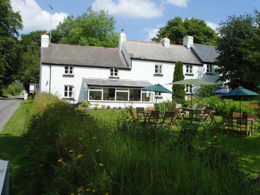 a white house with tables and chairs in front of it at Beechwood B&B in Postbridge