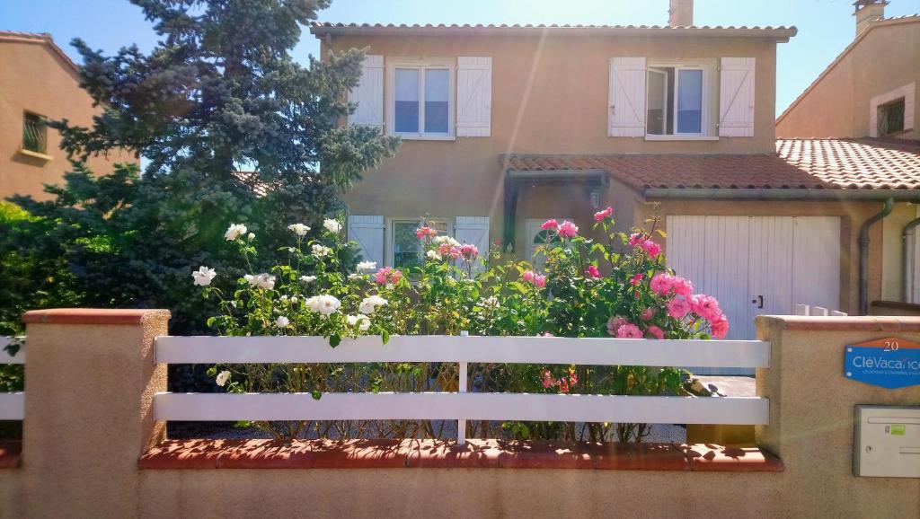 a white bench in front of a house with flowers at Fleurs de Cosmos in Albi