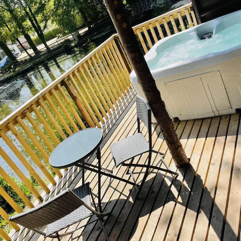 einen Tisch und Stühle auf einer Terrasse neben einem Pool in der Unterkunft Otter 4 Hot Tub - HuntersMoon-Warminster-Bath-Salisbury in Warminster