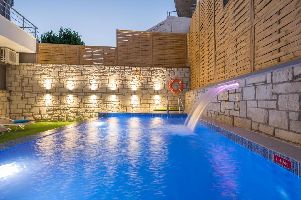 a swimming pool with a waterfall in a building at JT Apartments in Kissamos