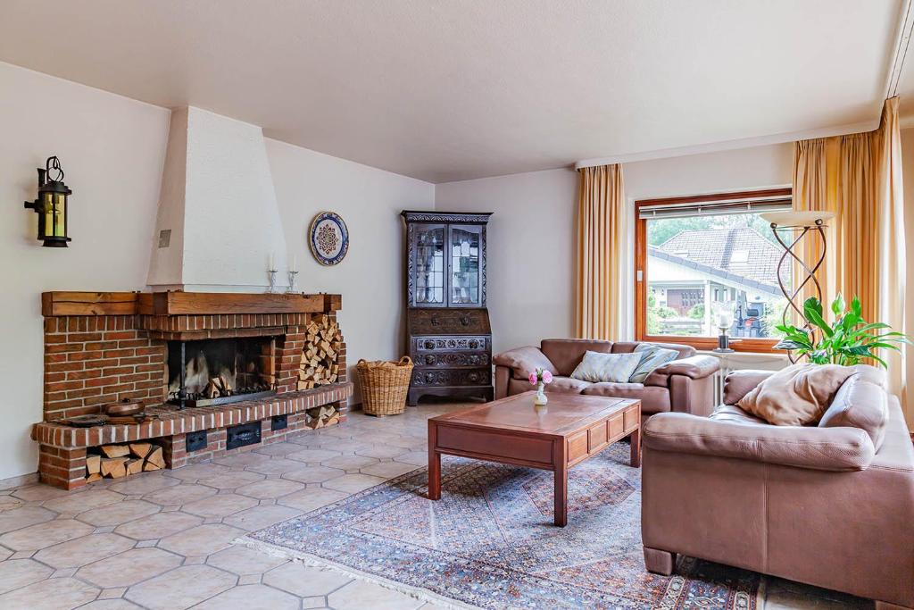 ein Wohnzimmer mit einem Sofa und einem Kamin in der Unterkunft Top-bewertete Komfort-Ferienwohnung mit Sonnenterrasse und Garten in der Lüneburger Heide in Hanstedt