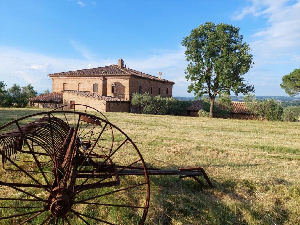 an old farm equipment in front of a building at Agriturismo Diffuso Monte Oliveto Maggiore in Chiusure