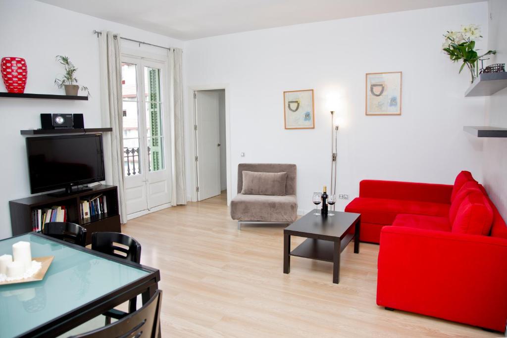 sala de estar con sofá rojo y silla roja en Claris Apartments en Barcelona