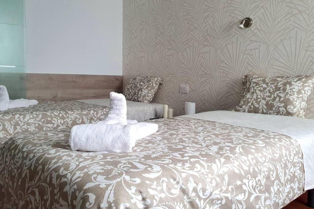 1 dormitorio con 2 camas y toallas blancas. en Comfy Box Las Canteras, en Las Palmas de Gran Canaria