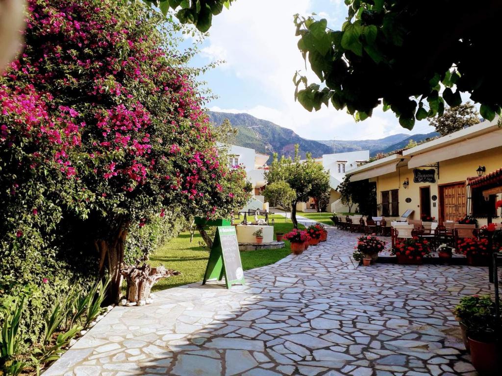 Una pasarela de piedra con flores y un cartel en ella en Le Due Sorelle, en Spilia