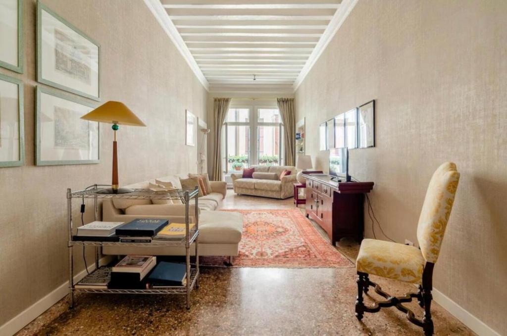 ein Wohnzimmer mit einem Sofa und einem Tisch in der Unterkunft Venezia San Samuele in Venedig