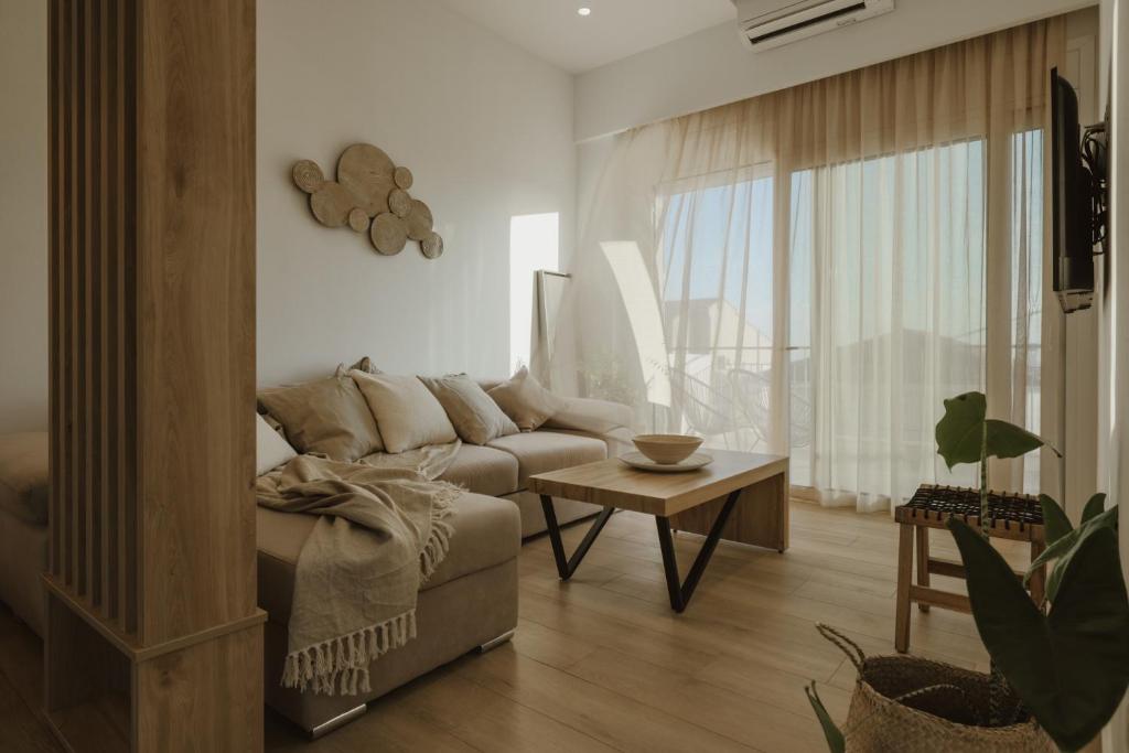 a living room with a couch and a table at Casa Costa Suites in Kanali