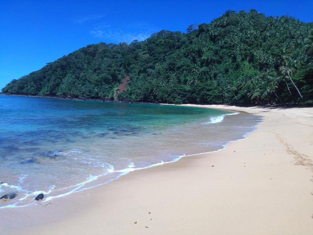 uma praia vazia com uma montanha ao fundo em Hotel Praia Inhame Ecolodge em Porto Alegre