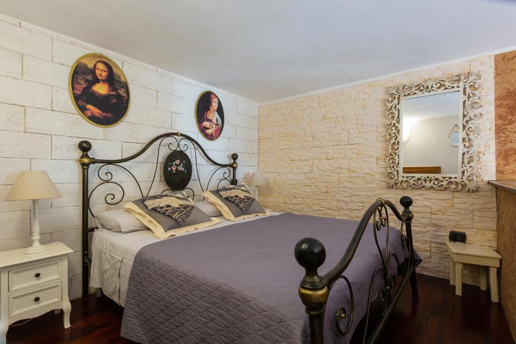 - une chambre avec un lit et un miroir mural dans l'établissement Dimora Santa Croce, à Lecce