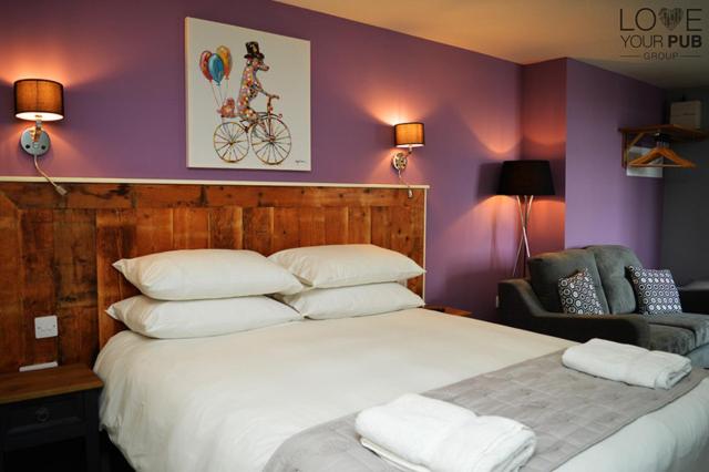 ウォーターロービルにあるrooms@73の紫の壁のベッドルーム1室(白い大型ベッド1台付)