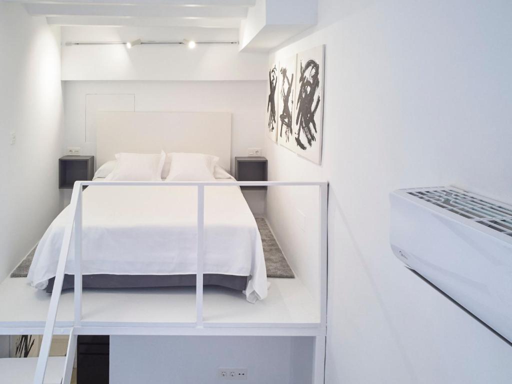 1 dormitorio blanco con 1 cama en una habitación blanca en Apartamento Calesa Centro Sevilla, en Sevilla