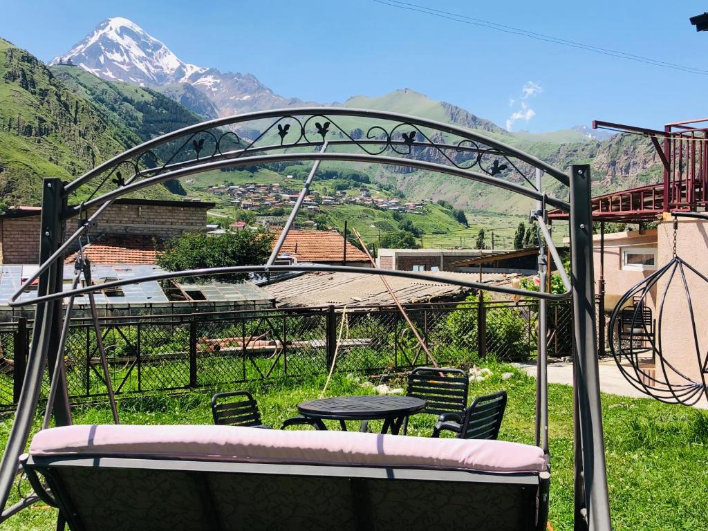 a patio with a table and chairs and mountains at Guest house chavchavadze N23 in Stepantsminda