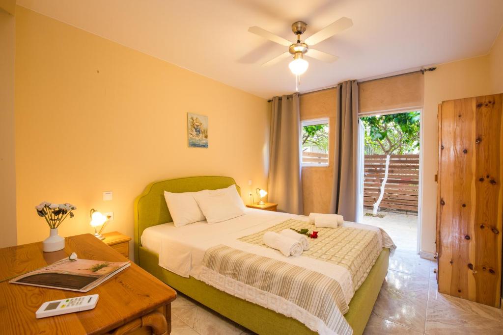 a bedroom with a bed and a table and a window at Limonero New City Apartment 1 with Private Parking in Lefkada