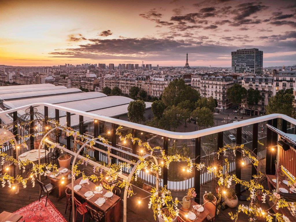 einen Balkon mit Beleuchtung und Stadtblick in der Unterkunft Novotel Paris Porte Versailles in Paris