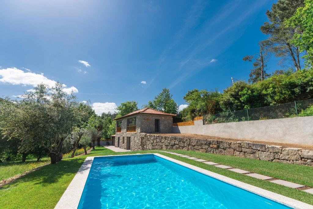 Cela的住宿－Casa Velha de Ponta Sôto，一座带房子的院子中的游泳池的形象
