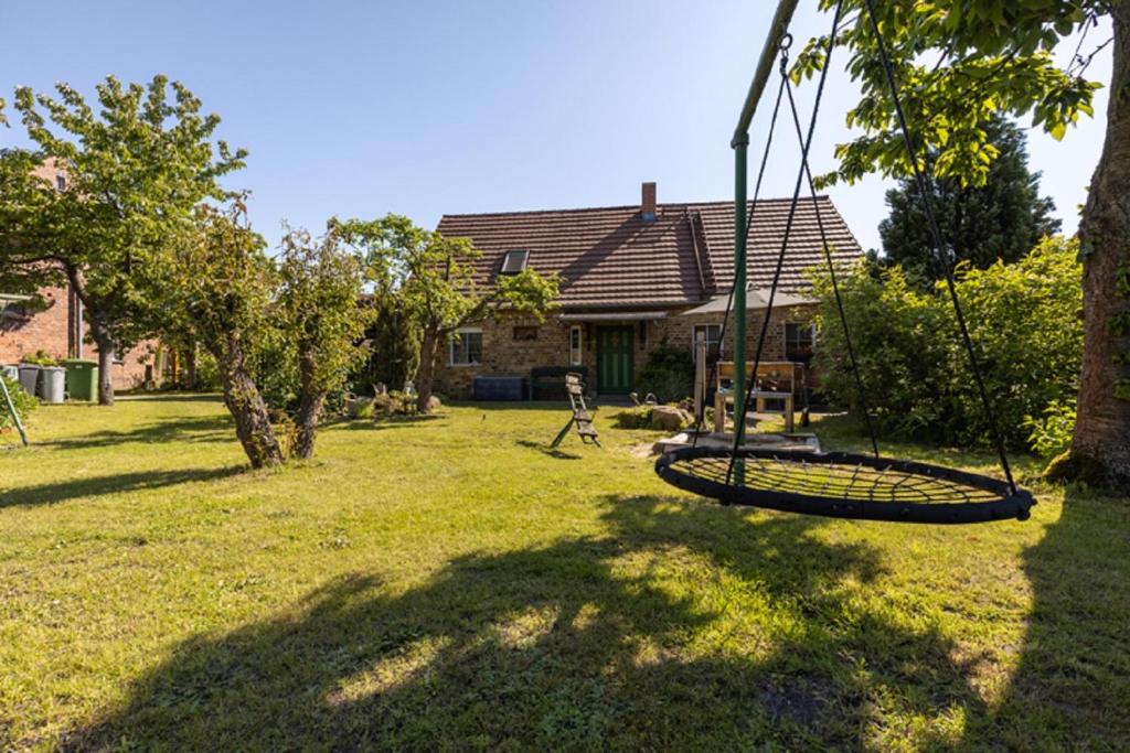 un patio con un columpio delante de una casa en Bauernhof Ladusch en Kolonie Baruther Berg