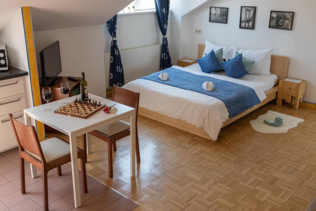 1 dormitorio con cama y mesa con tablero de ajedrez en Yeshello Central Station Studio, en Viena