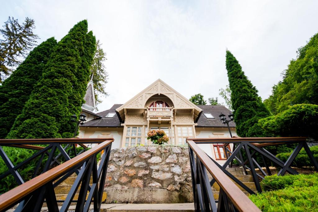 una casa con degli alberi di fronte di Hotel Tókert Szálloda és Étterem a Lillafüred