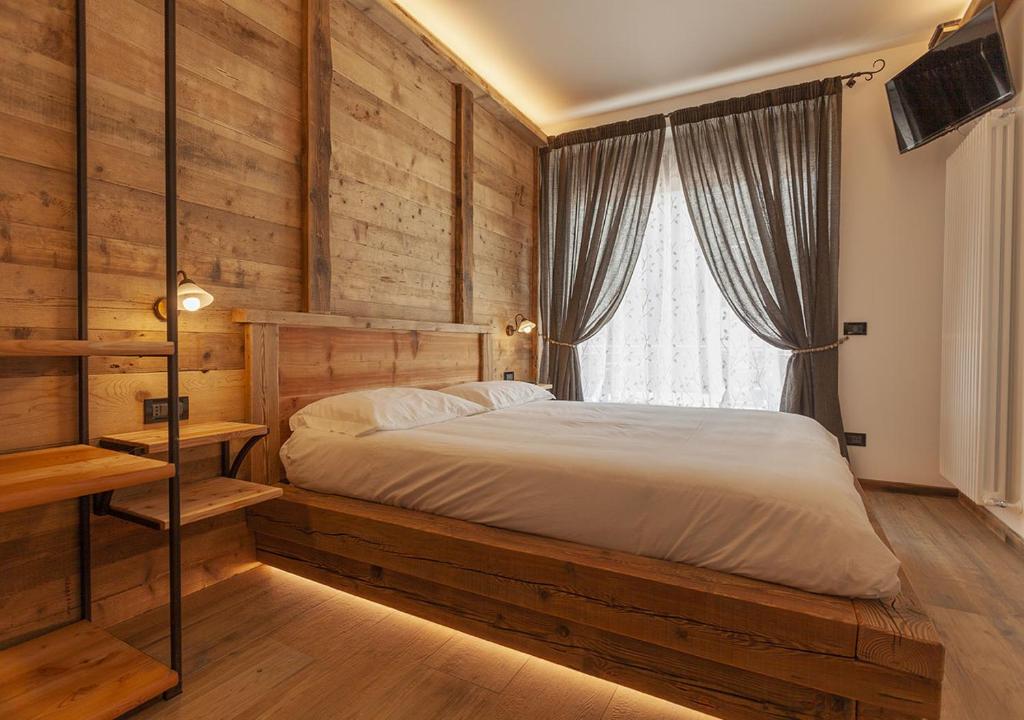 een slaapkamer met een bed en een raam bij Bed and Breakfast La Coa in Auronzo di Cadore