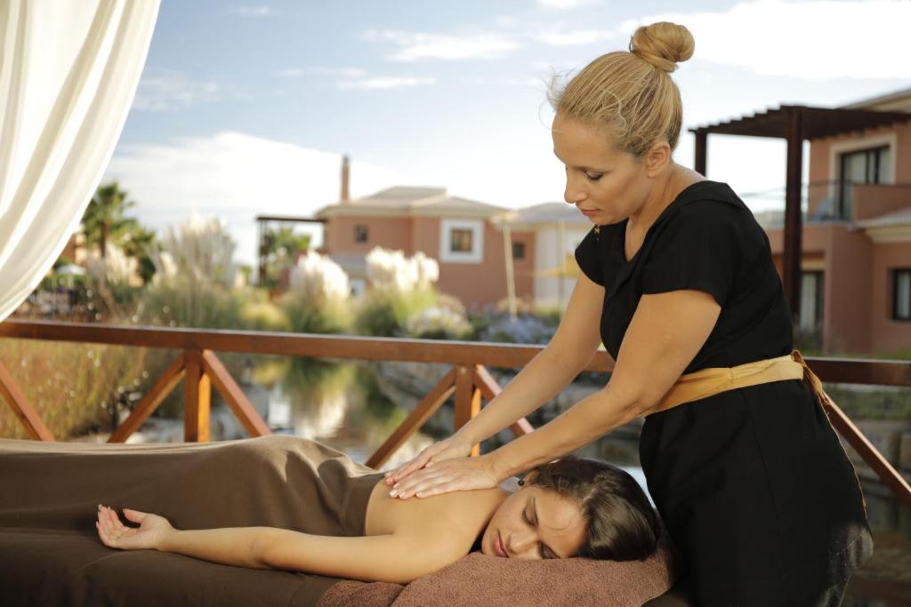 a woman is helping a woman on a couch at Monte Santo Resort in Carvoeiro