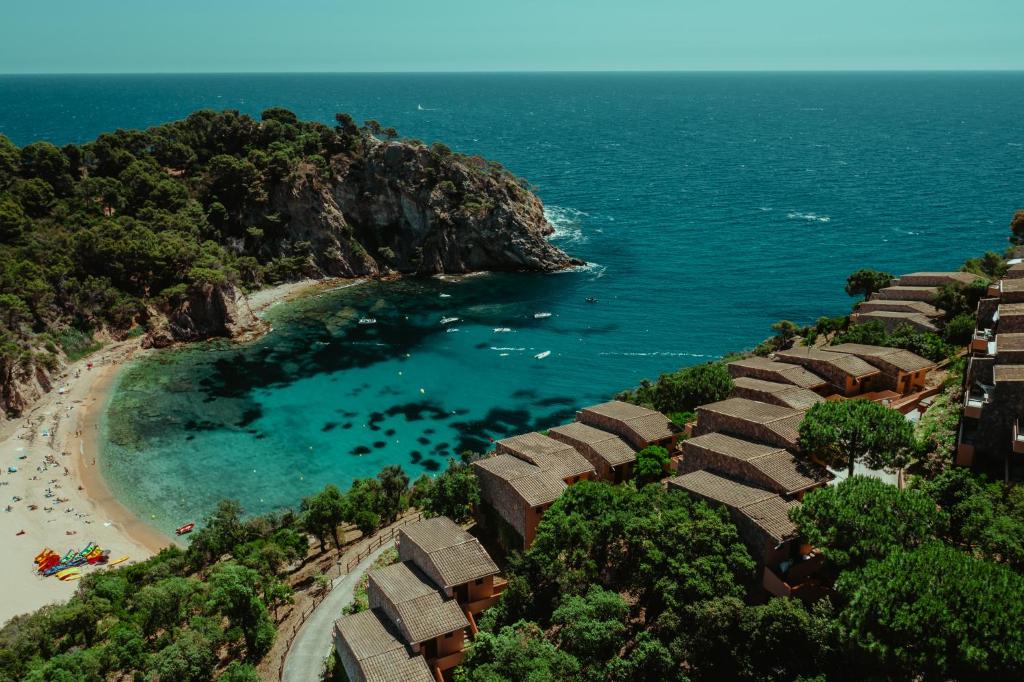 an aerial view of a beach with a group of huts at Pola Giverola Resort in Tossa de Mar