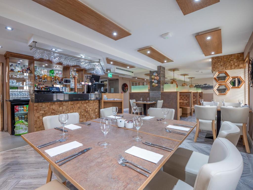 uma sala de jantar com uma grande mesa de madeira e cadeiras em Blackbull hotel em Tarbolton