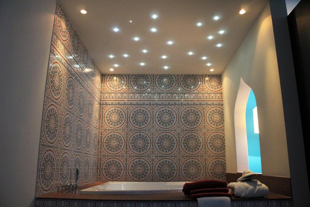 uma casa de banho com uma banheira e uma parede de azulejos em besttime Hotel Bendorf Koblenz em Bendorf