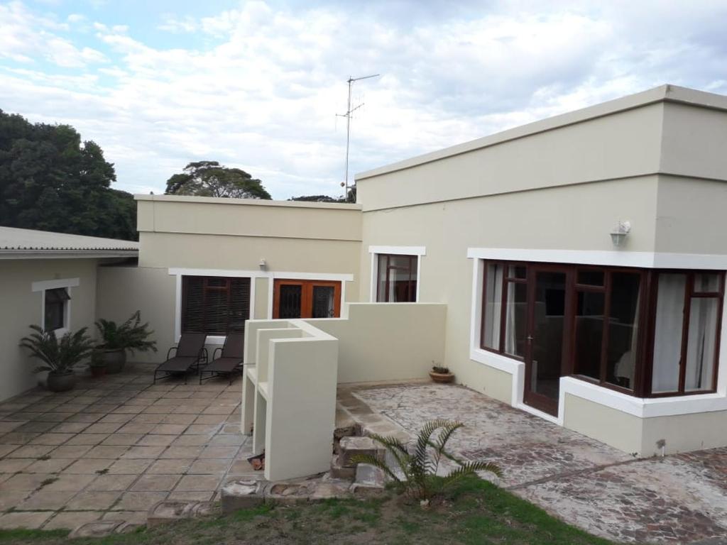 a white house with a patio in front of it at Leisure@Loerie in Sedgefield