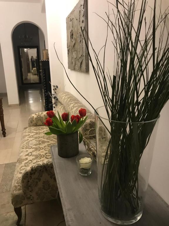 a table with a vase with red flowers on it at Fleur Blanche in Verona