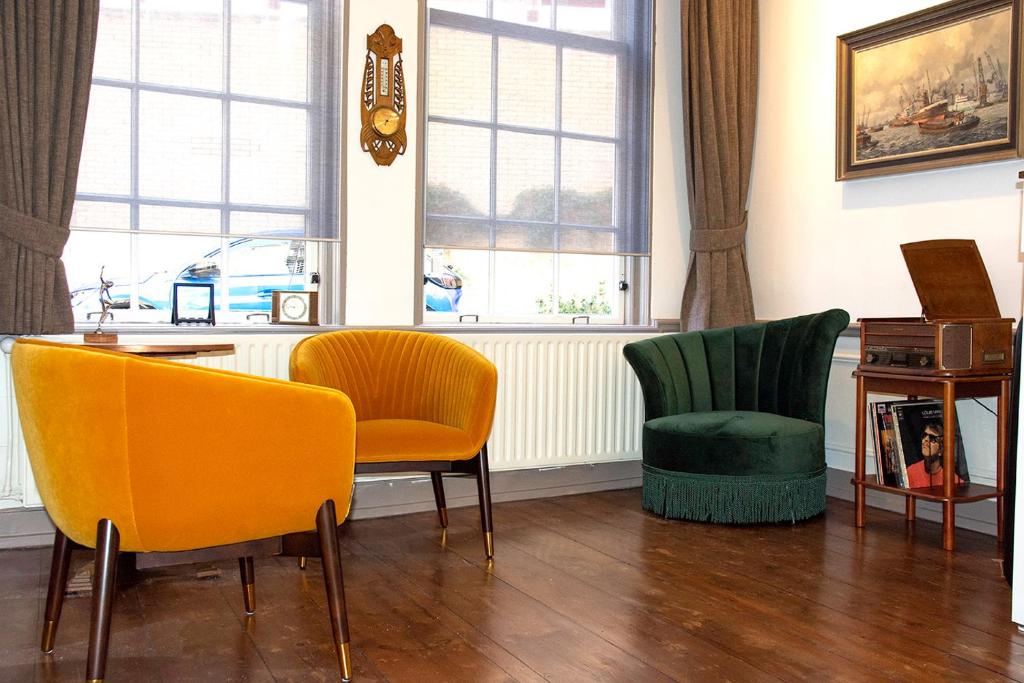 多德雷赫特的住宿－B&B Belle Chambre - Luxe in Art Deco stijl，客厅配有黄色和绿色的椅子和桌子