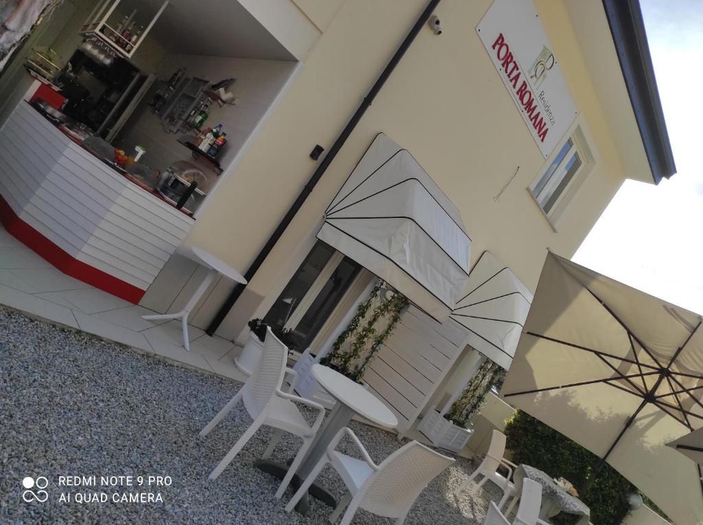 twee stoelen en een paraplu voor een gebouw bij Residenza Porta Romana in Tropea