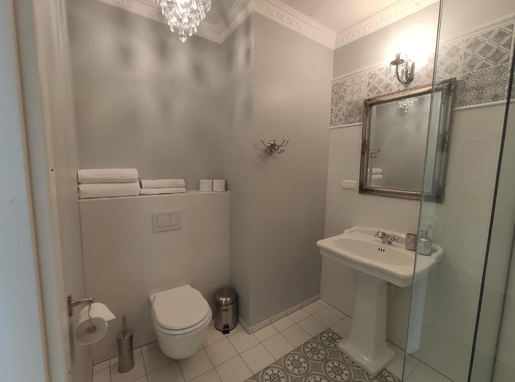 a white bathroom with a toilet and a sink at Raudteevalitsuse Villa in Pärnu