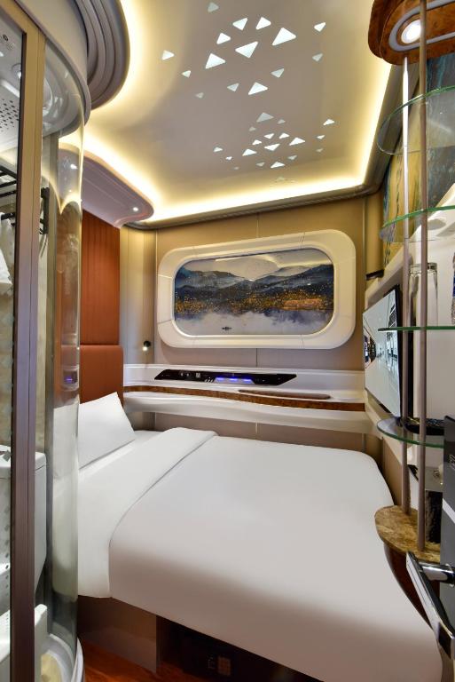a small room with a bed and a window at Bahrain Airport Hotel Airside Hotel for Transiting and Departing Passengers only in Muharraq