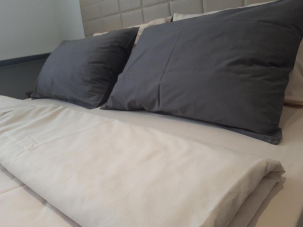 a bed with two gray pillows on top of it at 5 STAR CENTRAL STUDIO in Skopje