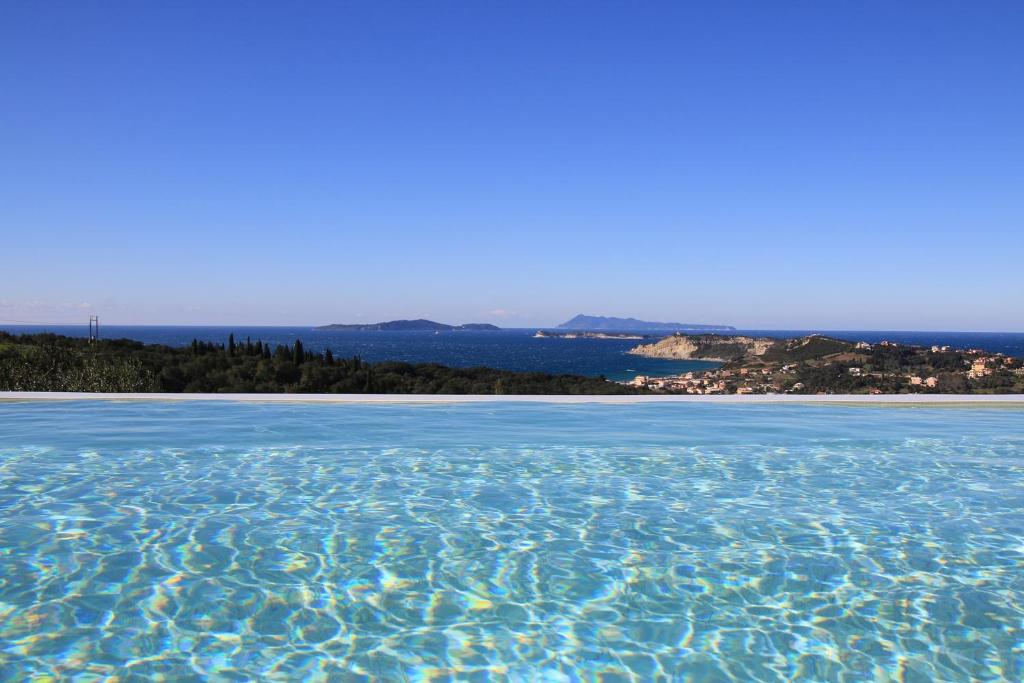 a pool of water with a beach in the background at Sunset Sea View Villa 5 in Arillas