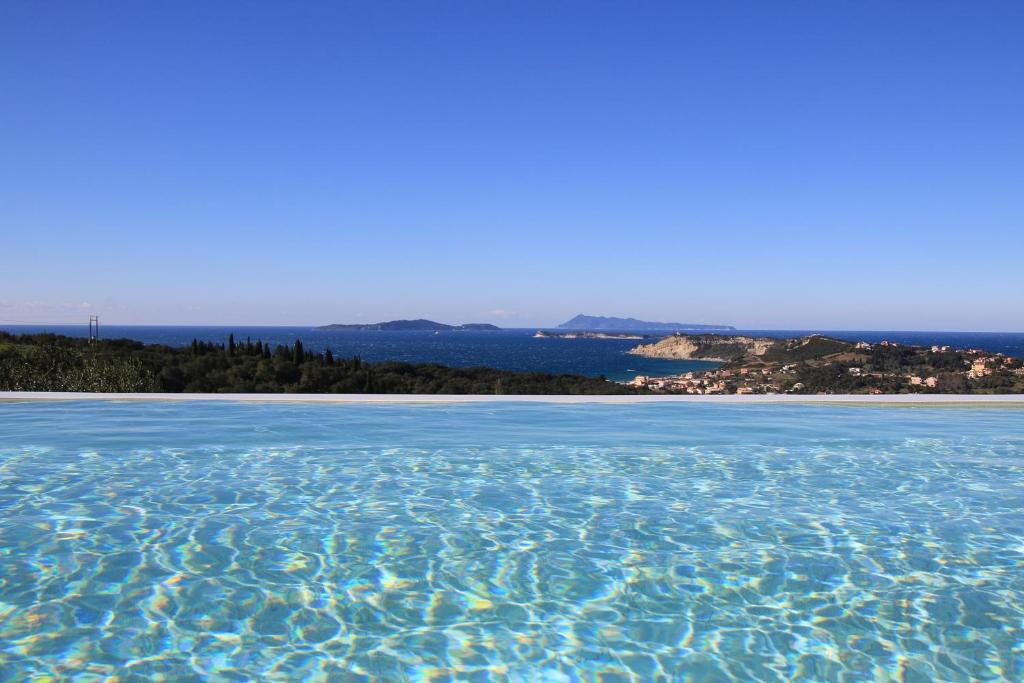 basen z wodą z plażą w tle w obiekcie Sunset Sea View Villa 5 w mieście Arillas