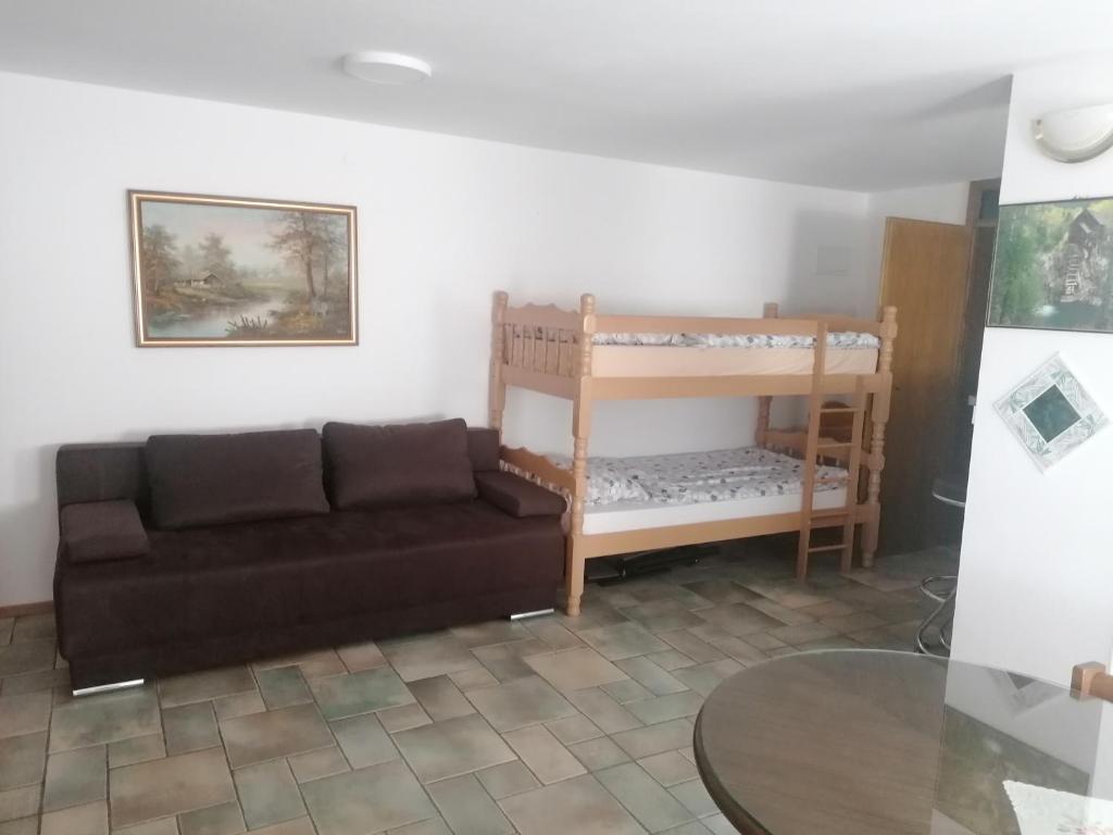 - un salon avec un canapé et une table dans l'établissement Apartma Gače, à Semič