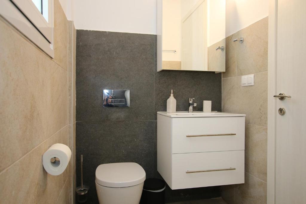 Łazienka z białą toaletą i umywalką w obiekcie Sunset Sea View Villa 5 w mieście Arillas