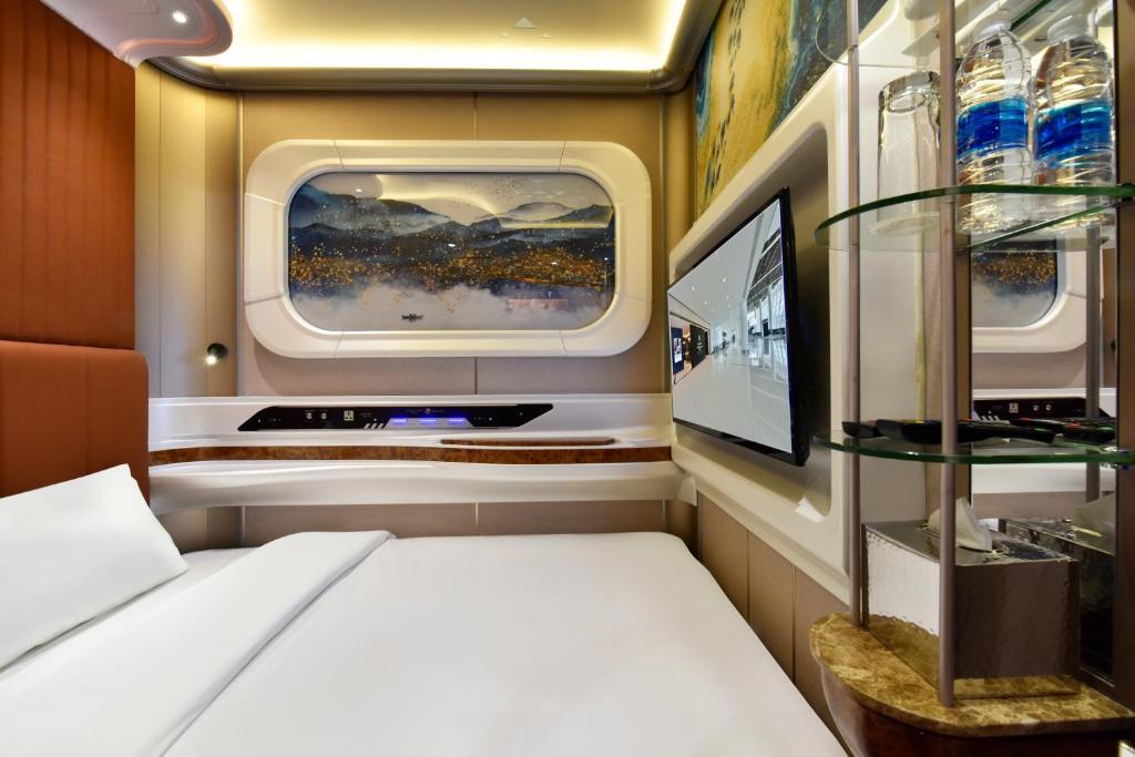 a small room with a bed and a tv at Bahrain Airport Hotel Airside Hotel for Transiting and Departing Passengers only in Muharraq