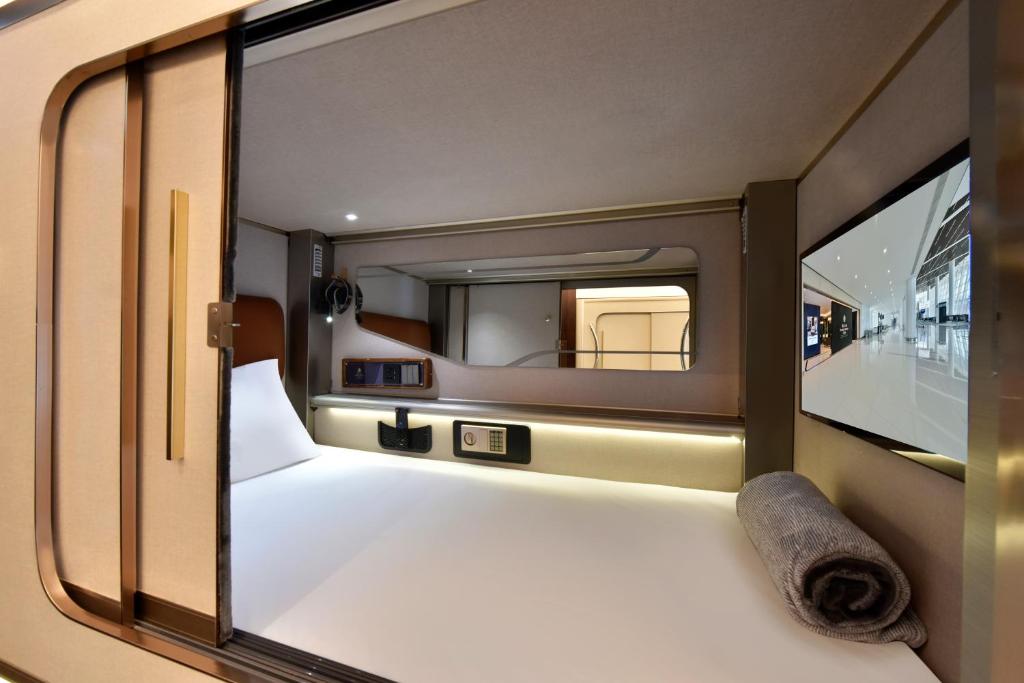 a view of a bed in a room with a mirror at Bahrain Airport Hotel Airside Hotel for Transiting and Departing Passengers only in Muharraq