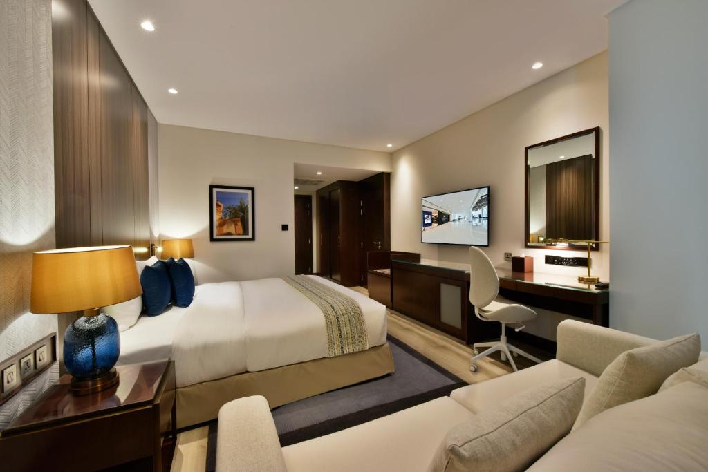 a hotel room with a bed and a desk at Bahrain Airport Hotel Airside Hotel for Transiting and Departing Passengers only in Muharraq